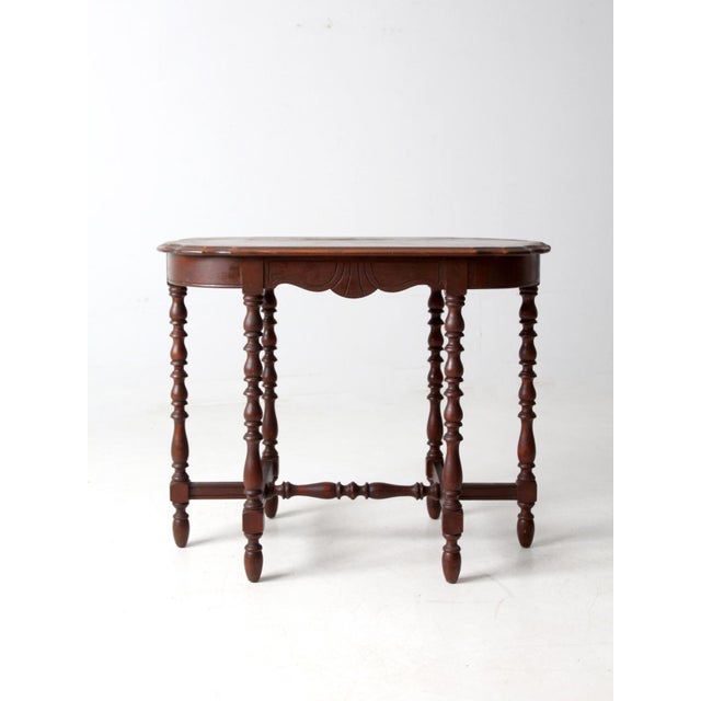 This early 20th century accent table reflects the Colonial Revival style with a touch of cottage charm. The scalloped-edge...
