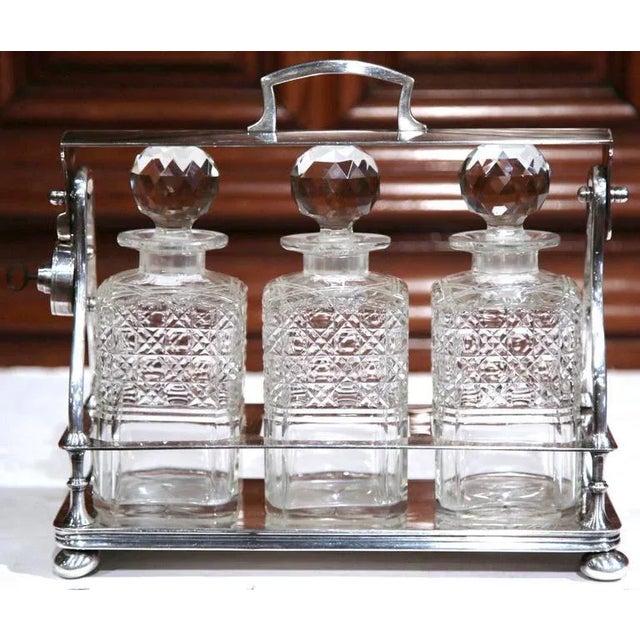 Entertain in style with this beautifully crafted, antique Tantalus from England. Crafted, circa 1860, the bar accessory is...