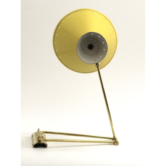 This articulated swing-arm wall light was designed by Rene Mathieu and was produced by Lunel in France. It has a double...
