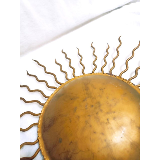 Vintage Sunburst lamp crafted from gold-plated metal, featuring a radial design of undulating rays emanating from a...