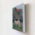This artwork depicts a solitary white horse standing amidst a muted landscape, its presence emphasized by a striking red...