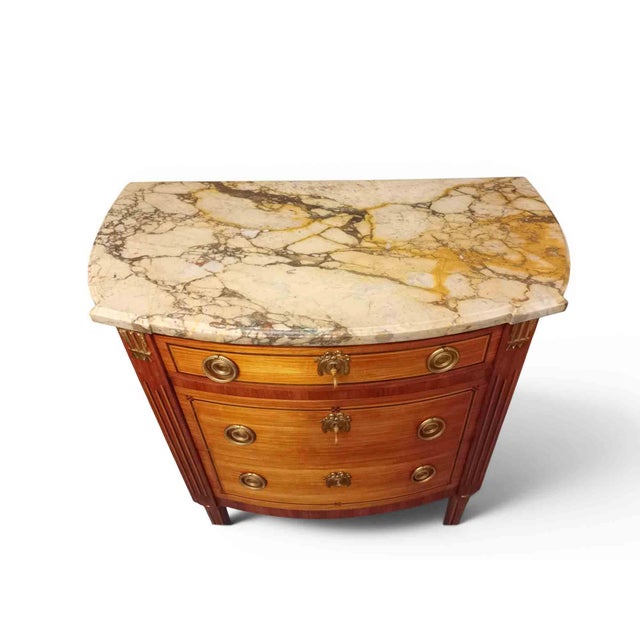 Small Louis XVI style marquetry commode with a half-moon shape. It features two drawers without a central divider and a...