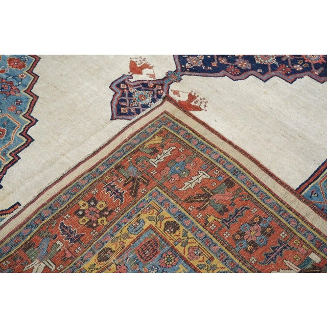 In a "book-cover" design, with an open ivory field, pointed at the ends, supporting a stepped navy Herati medallion with...