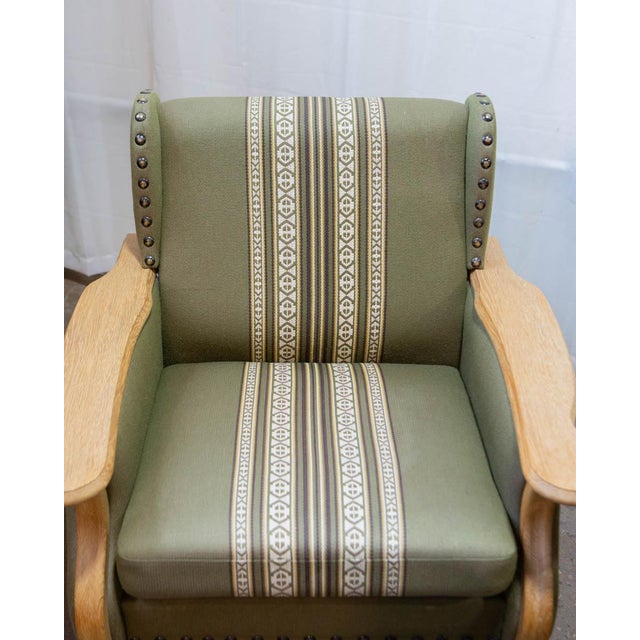 A matched pair of Danish oak lounge chairs by Henning Kjærnulf, produced in the 1960s and offered with the original...