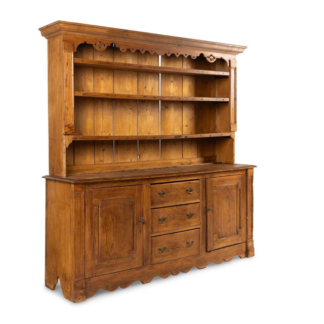 A handsome example of an antique English oak Welsh dresser, this piece showcases the warm patina and honest craftsmanship...
