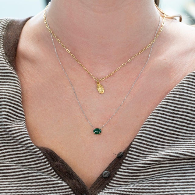 Elevate your elegance with this stunning 1.2 carat Zambian emerald pendant necklace. The vibrant oval emerald, measuring...