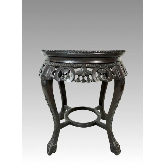 Antique Chinese rosewood stool, plant stand or pedestal with inset rose pink/beige marble round top. The dark brown wood...