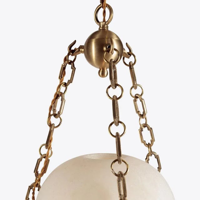 A beautiful carved alabaster globe is suspended from brass chains to create a hanging lantern. The alabaster features a...