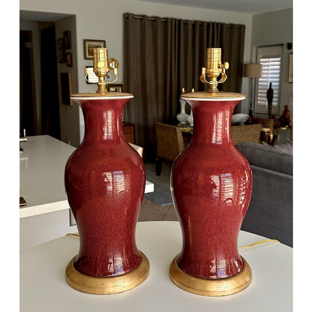 Pair of 19th century Chinese Asian Sang De Boeuf "Oxblood" glazed vases as table lamps mounted on turned giltwood bases....