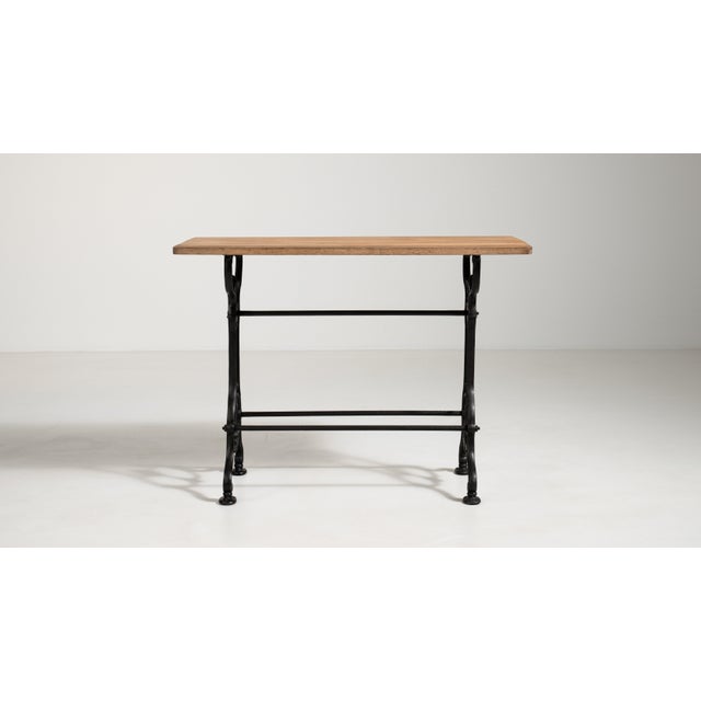 A classic French 20th century bistro side table with a durable cast iron base and a warm wooden top. The robust iron...
