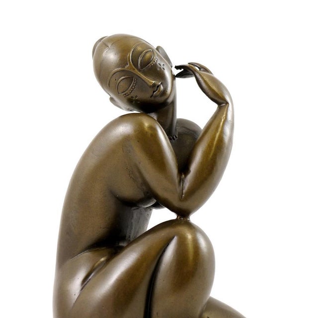 This Art Deco brown patinated bronze female nude sculpture from the 20th century is mounted on a green marble base. The...