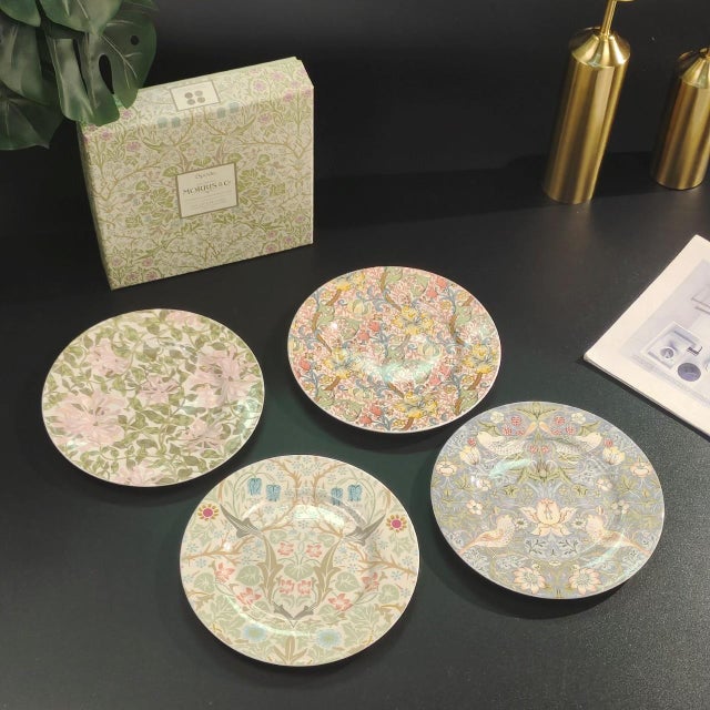 This is a set of four ceramic plates featuring exquisite floral patterns. These plates are a wonderful way to add color...
