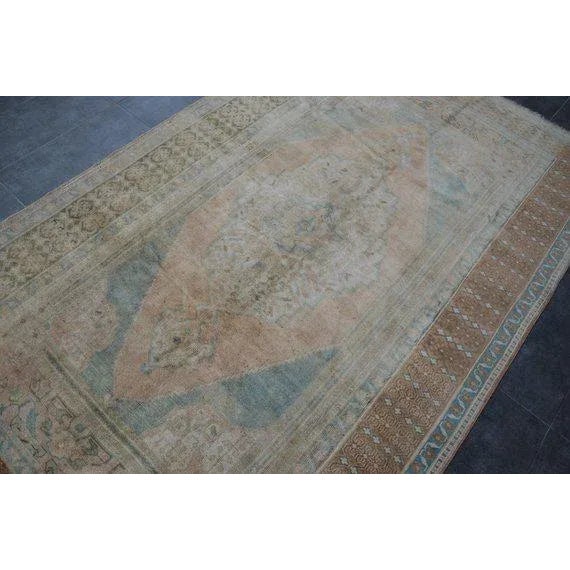 This is a vintage Turkish Oushak rug from the 1960s. The piece was hand-knotted.