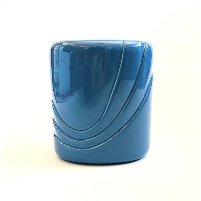 A vintage 1980s ceramic vase. Glossy periwinkle glaze with curved embossed detailing. Measures 7"W x 4.75"D x 8"H
