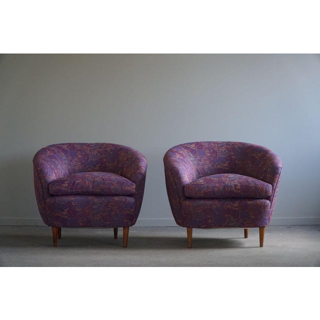 A magnificent pair of curved club chairs, reupholstered in a luxurious vintage fabric stored from the 1980s. This nicely...