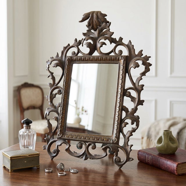 Ornate Rococo Revival tabletop mirror with elaborate scrollwork, acanthus leaf detailing, and a shell crest. Made from...