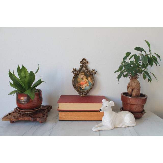 Vintage religious wall hanging print with Mary, Jesus and Cherub. The frame features cherubs and ribbon detail. Made in...