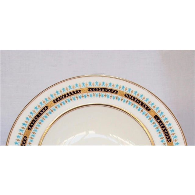 An antique set of 12 porcelain bowls by Coalport for Tiffany and Company. White in color with highlights of black, gold...