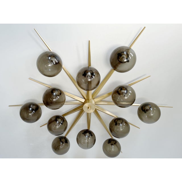 Italian midcentury flush mount with 12 large smoky Murano glass globes mounted on solid brass frame in satin brass finish...