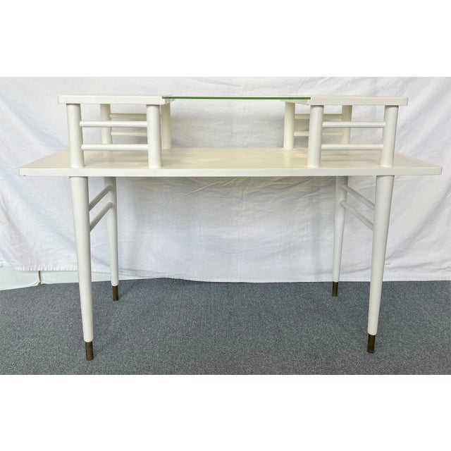 Great little mid century modern table. The table has clean lines, an upper and lower surface, and brass capped feet. The...