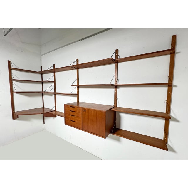 Midcentury "Cado " style wall-mounted shelving unit in teak, circa 1960s, from the "Veggen de Luxe" line, designed by...