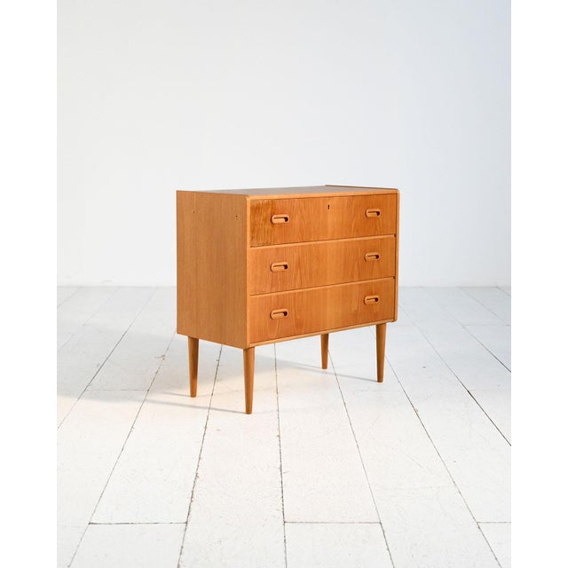 Oak chest of drawers with three drawers, integrated handles, and tapered legs. Scandinavian production, 1960s....