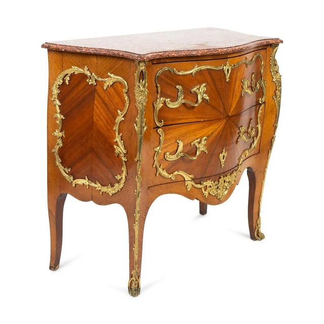 An elegant Louis XV Style Bombe Commode with Sunburst Veneer and Gilt Metal Mounts, late 19th century example of gilded...