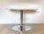 Round 1990s table produced by the Calligaris company, ivory lacquered wooden top and chromed steel base. This piece has an...
