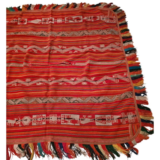 A striking 1960s Andean handwoven wool poncho textile featuring an exceptional combination of traditional figural, animal,...