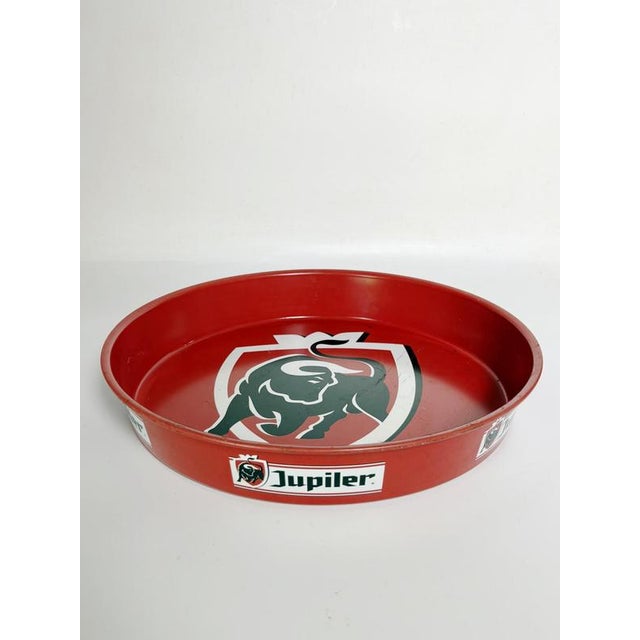 French advertising tray in red and black lacquered metal, 1960s. This circular metal advertising tray features a red and...