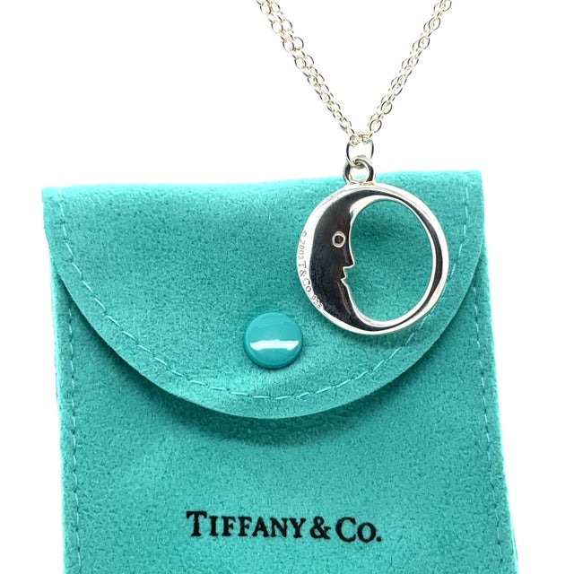 A rare Tiffany & Co. Man in the Moon necklace crafted in sterling silver, featuring a distinctive sculptural moon pendant...