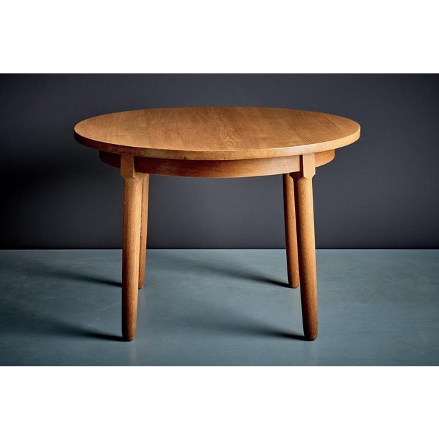 Round dining table in solid oak, finished in a warm, honey tone. The thick circular top sits on a simple apron with four...