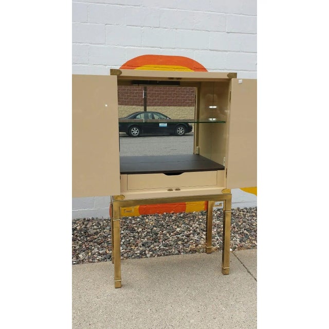 Stunning and rare Mastercraft bar cabinet. The top bar cabinet which is lacquer over wood sits atop a brass base with the...