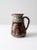 This vintage studio pottery pitcher is a signed work by the artist, featuring a stunning speckled glaze and a delicate...