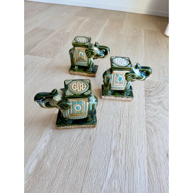 A distinctive set of three vintage Chinese export ceramic elephant pedestals featuring a traditional Sancai-style (three-...