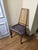 Four tall mid-century dining chairs with woven cane backs, tapered walnut-tone frames and upholstered seats. Details: -...