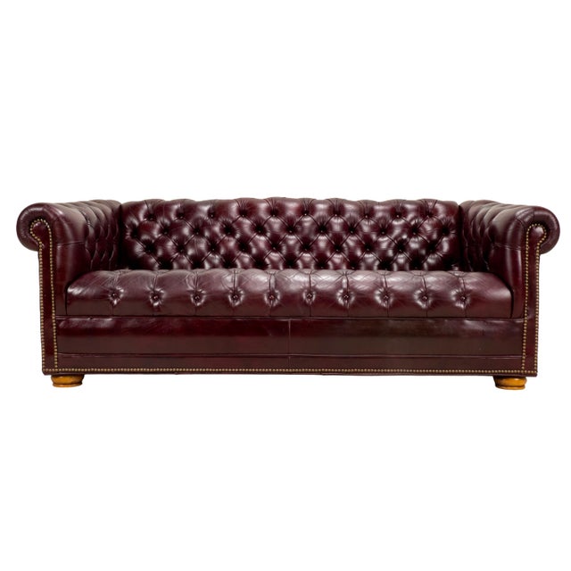 A handsome vintage Chesterfield sofa dating to the 1970s, upholstered in rich burgundy leather with deep button tufting,...