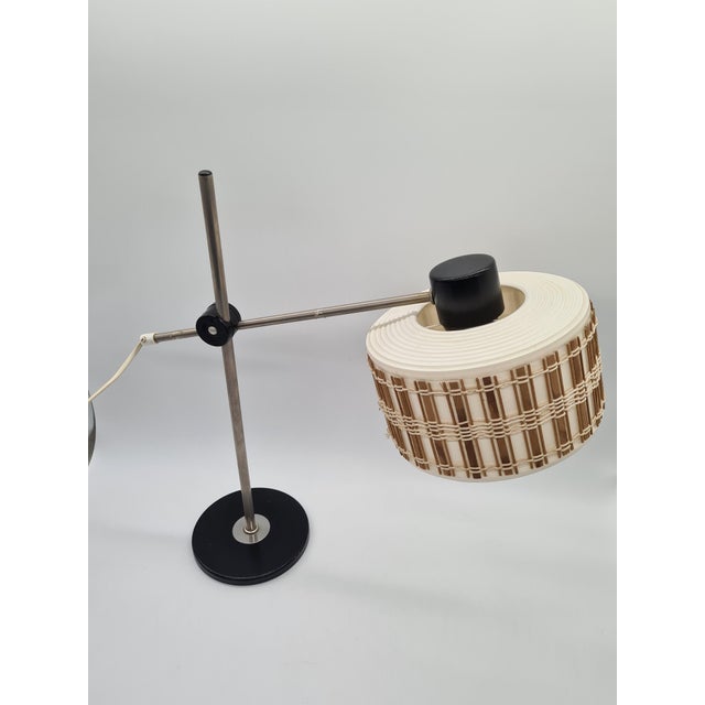 This table lamp from Germany from the 1970s centers around a cylindrical shade in a warm, creamy white shade that diffuses...