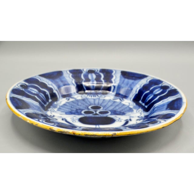 Dutch Delftware blue and white 'Peacock' plate, It is circa late 18th Century It is hand painted with an ochre rim, the...