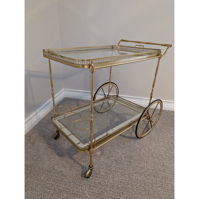 Beautiful glass and brass bar cart. The glass top has a mirrored edge. Wheels roll well.