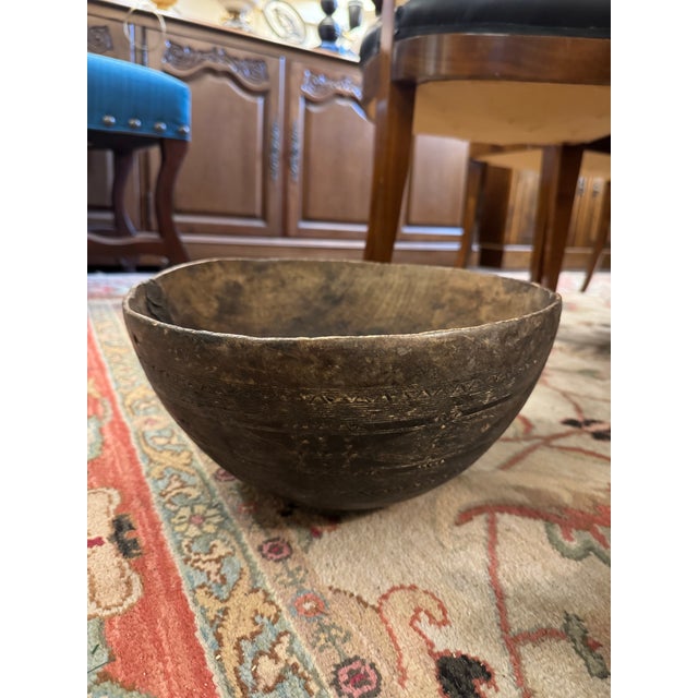 A beautifully hand-carved mid-20th century West African wooden dinner bowl, likely from Mali, sculpted from a single piece...