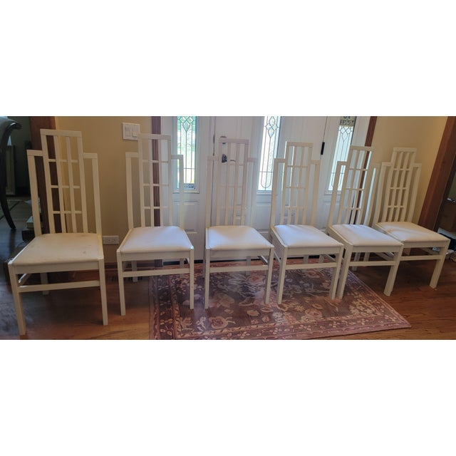 A set of six Abel Gonzalez white lacquer tall-back modern dining room chairs with white textured cushion seats. Three have...