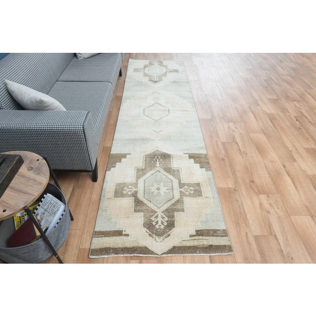 Vintage Hand-Knotted runner rug is a semi-antique vintage area rug. The '70s Eastern region of Anatolia's unique rug is...