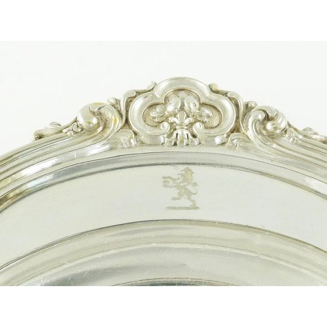 An antique Elkington tray or service plate with scroll and foliate borders along with armorial crests. Lion rampant...