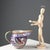 A glazed majolica jug decorated with Greek frets, fantastic animals, and a vase under a spout. Manufacturer's mark under...