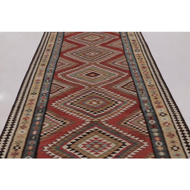Made with handwoven wool circa 1950-1960, this 6x15 vintage flat-weave gallery runner Kilim is a particularly impressive...