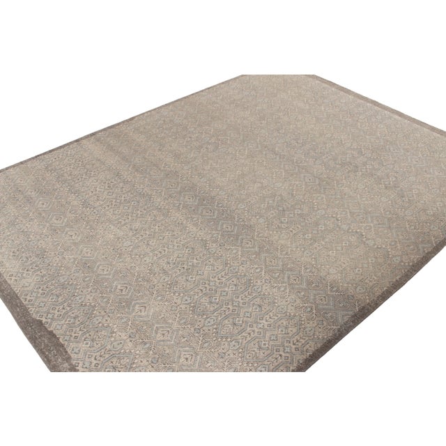 A 10x13 hand-knotted wool rug from the Homage Collection by Rug & Kilim. Enjoying silver-gray background with white and...
