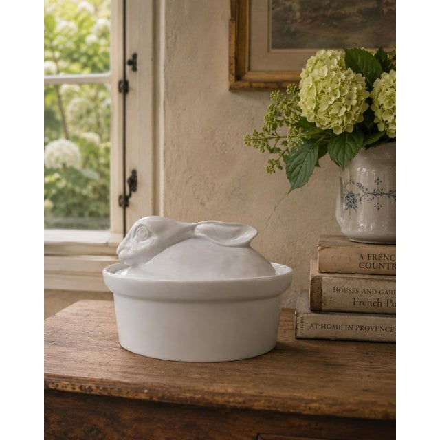 A charming vintage ceramic covered dish fashioned as a resting rabbit, its gently modeled head and long ears forming the...