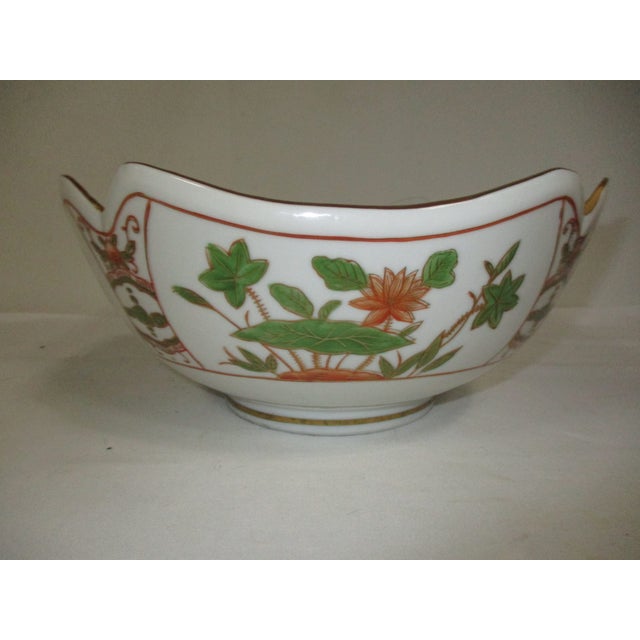 A hand-painted Andre by Sadek porcelain bowl. It has a scalloped shaped rim with gold trim. The sides both inside and...