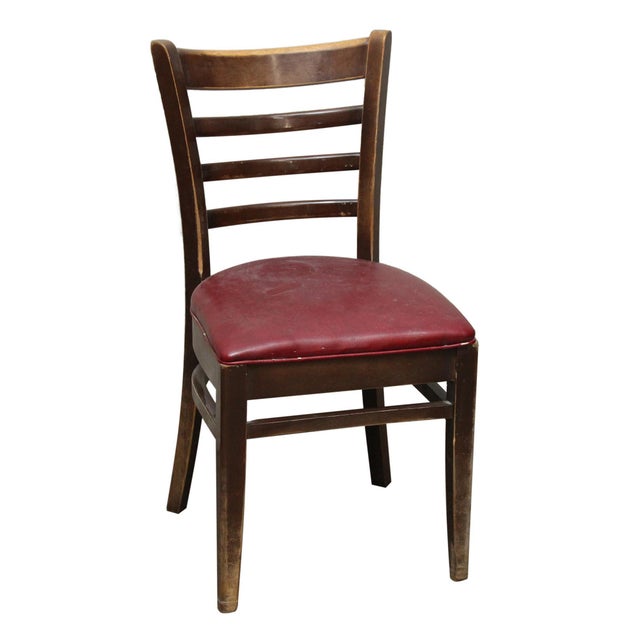 Pair of dark stained wood chairs with red vinyl seats. The exact date of creation is unknown. The dimensions are Floor to...